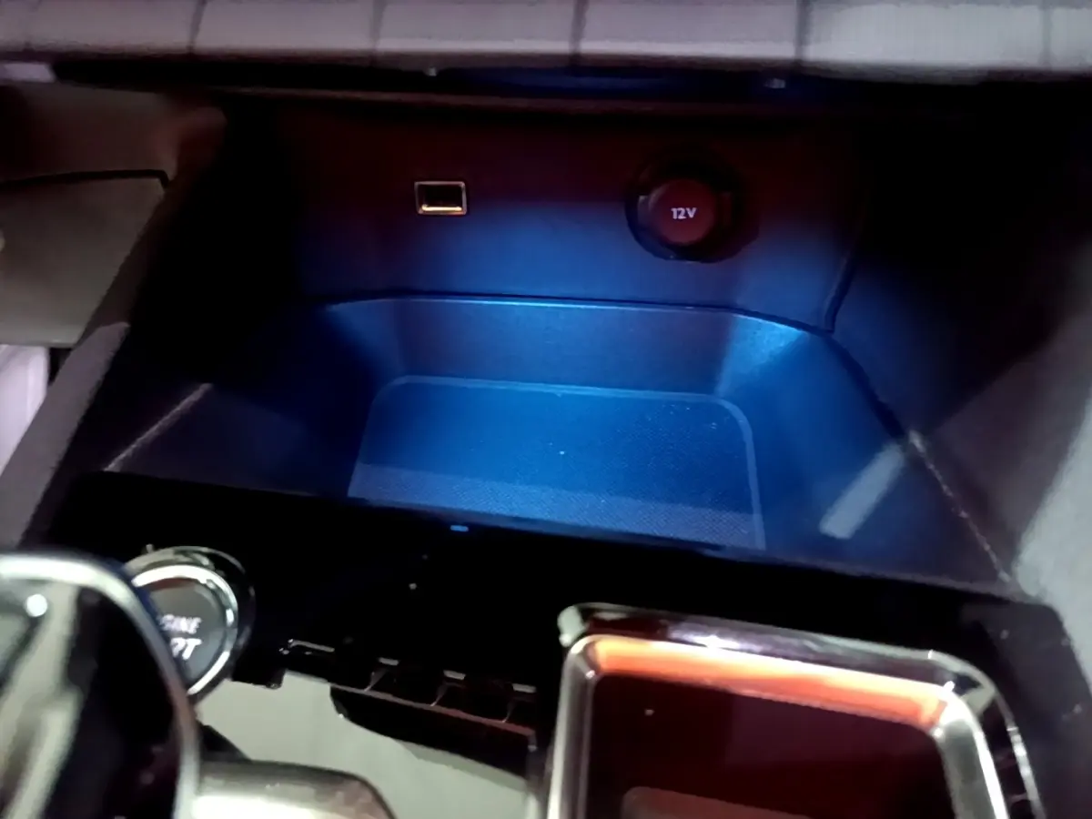 Gros plan sur la prise 12V et port USB dans le rangement central du Peugeot 3008 noir, version 2022.