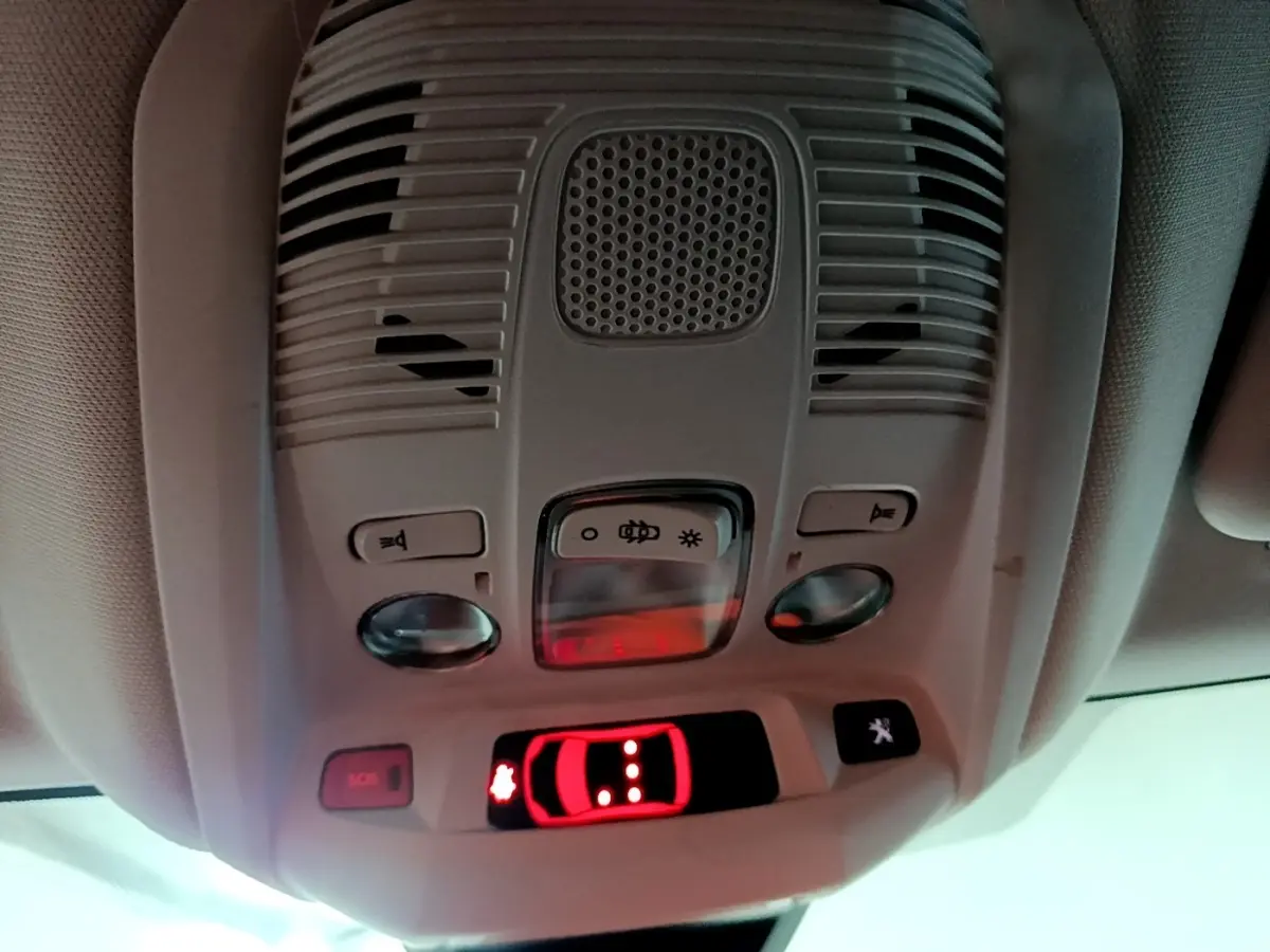 Vue intérieure en gros plan du plafonnier gris avec commandes d’éclairage et bouton SOS du Peugeot 3008 noir 2022.