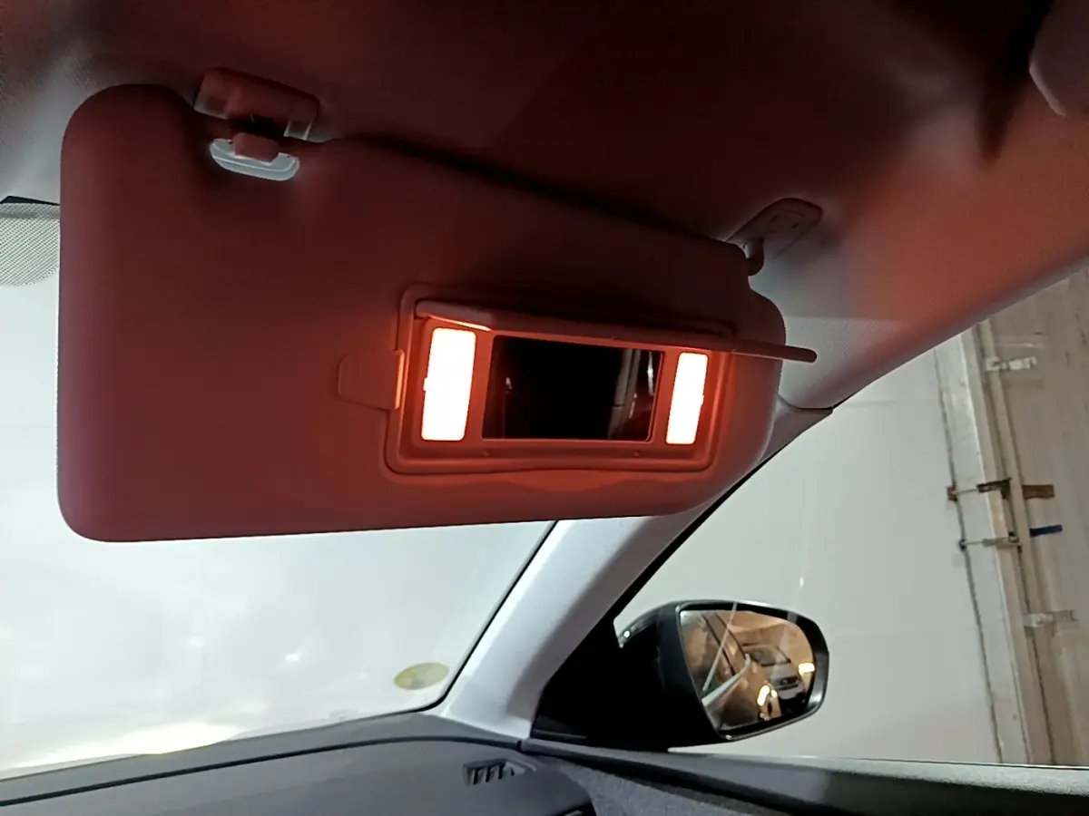 Vue intérieure du pare-soleil côté conducteur avec miroir éclairé dans un Peugeot 3008 noir de 2022.