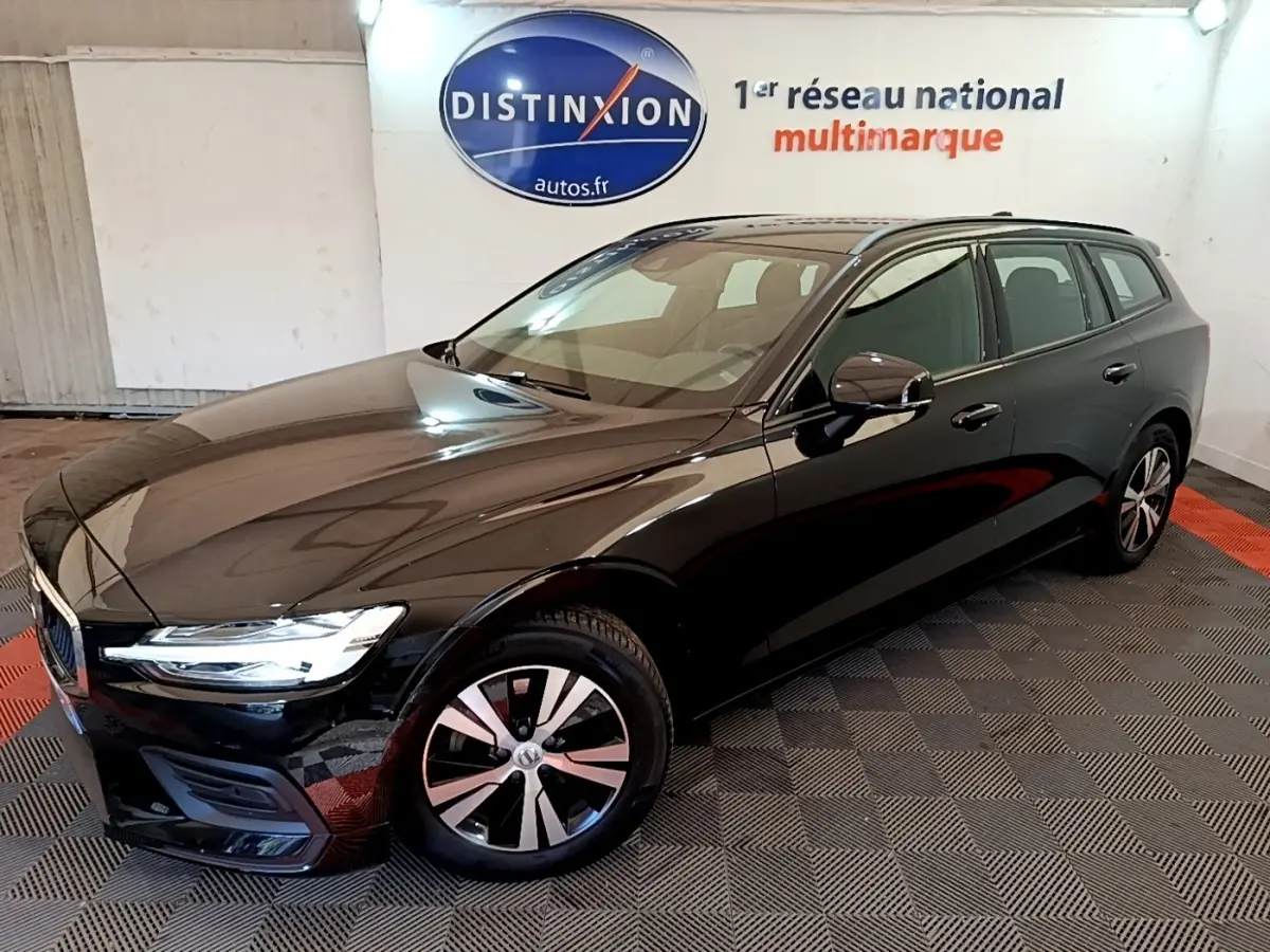 Volvo V60 D3 Business noire vue 3/4 avant droit en intérieur avec jantes alliage et feux LED allumés.