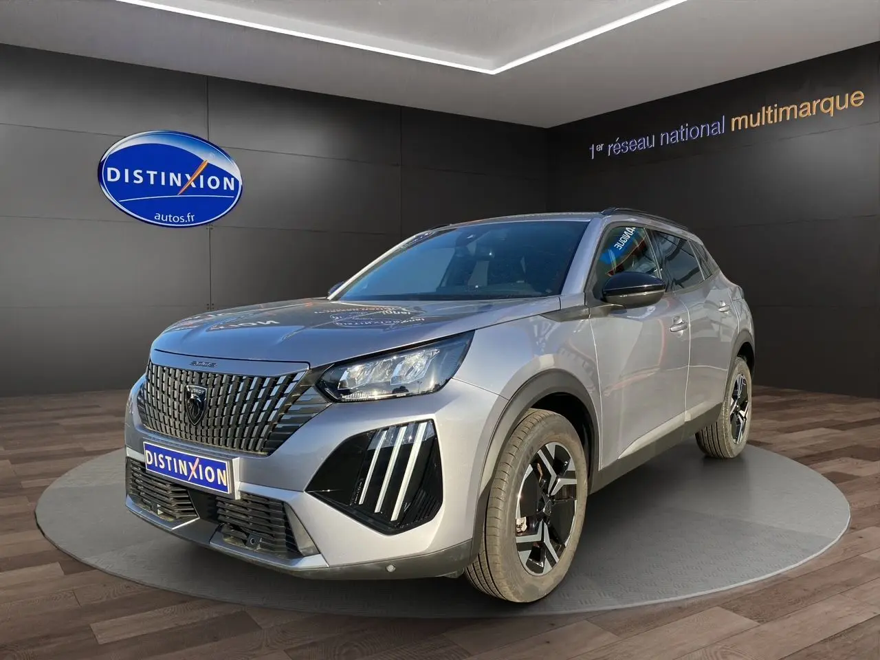 Peugeot 2008 gris Artense vue 3/4 avant droit, mettant en valeur sa calandre noire distinctive et ses phares LED.