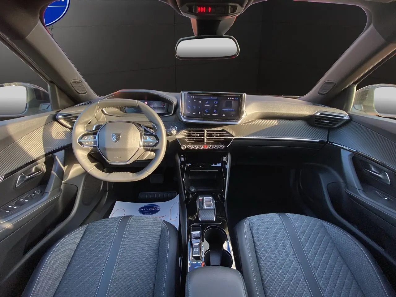 Intérieur du Peugeot 2008 2024 en gris, vue frontale du tableau de bord avec volant compact et écran tactile central.
