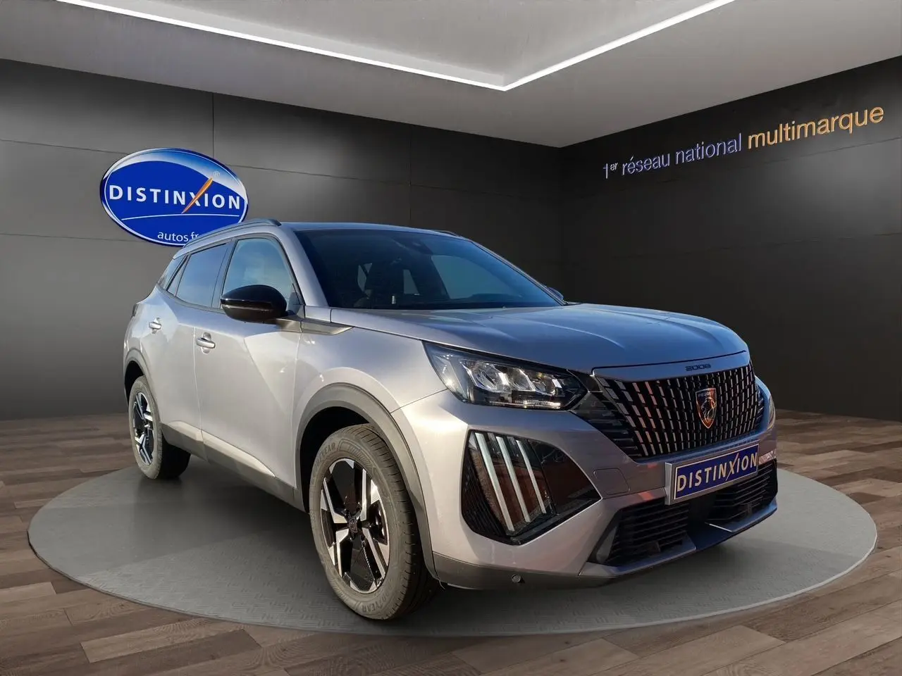 Peugeot 2008 gris Artense en 3/4 avant droit, avec calandre noire et phares LED distinctifs.