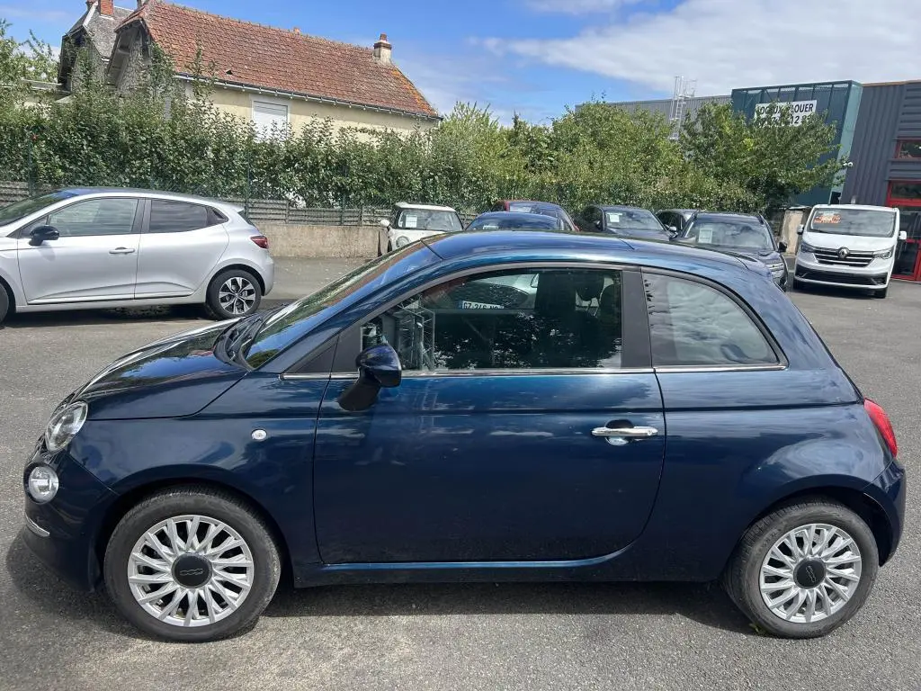 Profil côté gauche d'une FIAT 500 2024 bleu avec jantes alliage 16'' Spider et toit vitré panoramique fixe.