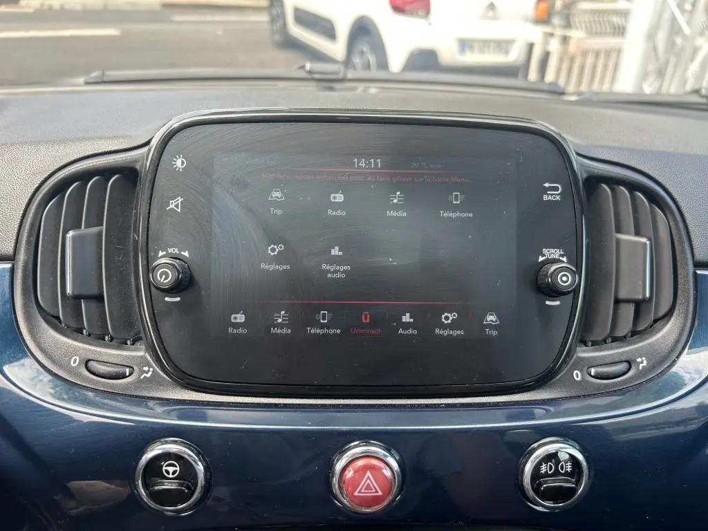 Tableau de bord bleu de la Fiat 500 2024 avec écran tactile central et commandes circulaires d’aération visibles.