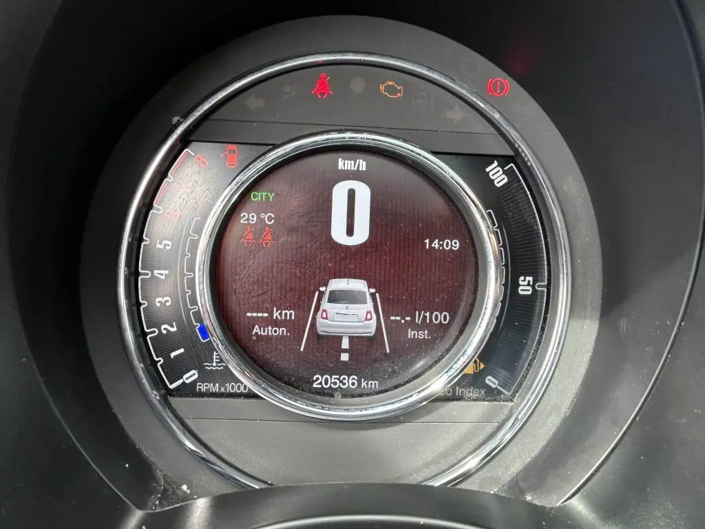Tableau de bord circulaire du Fiat 500 2024 affichant la vitesse à zéro et un visuel arrière du véhicule en gris.