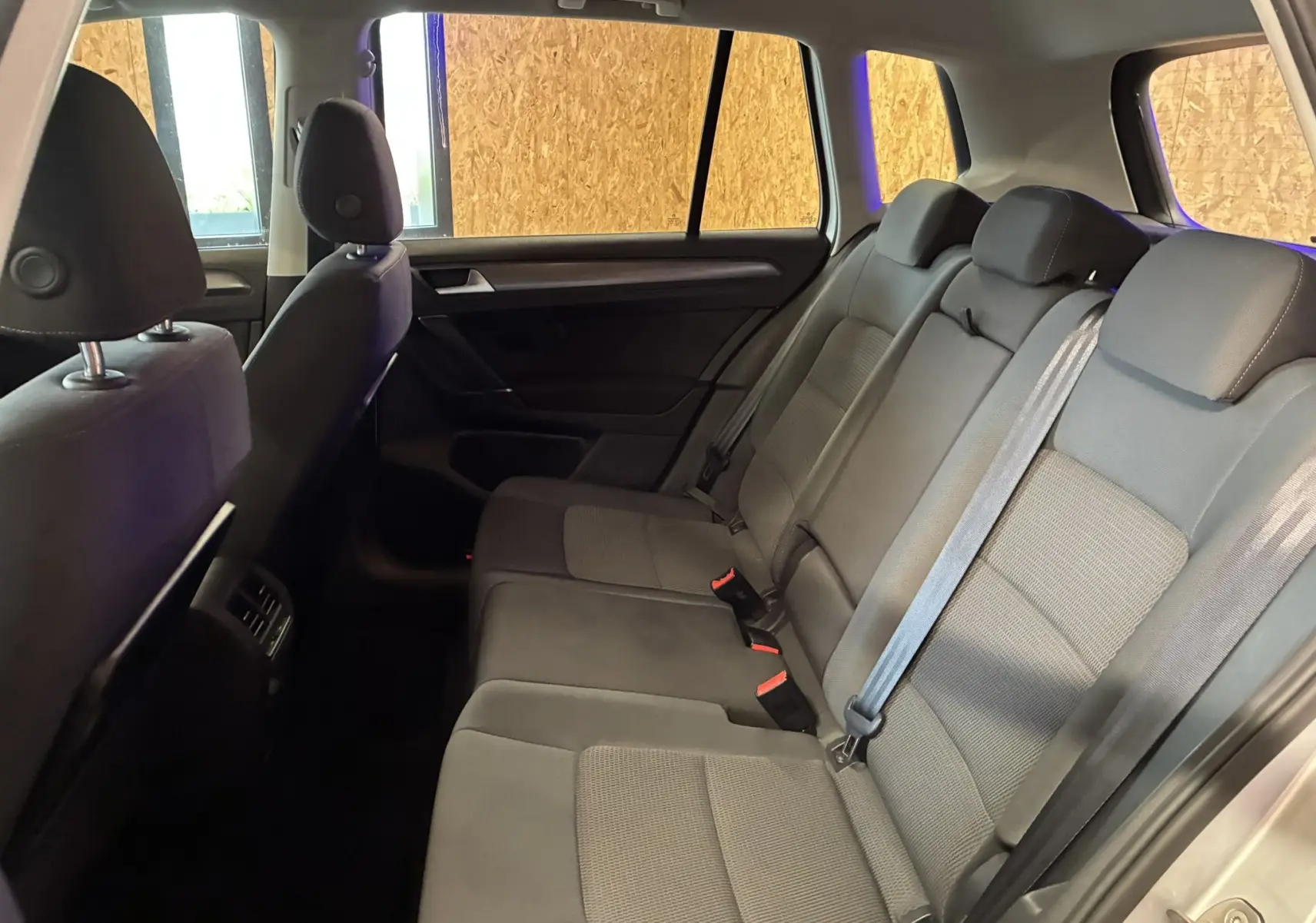 Vue latérale intérieure montrant les sièges arrière en tissu gris noir du Volkswagen Golf Sportsvan 2019.
