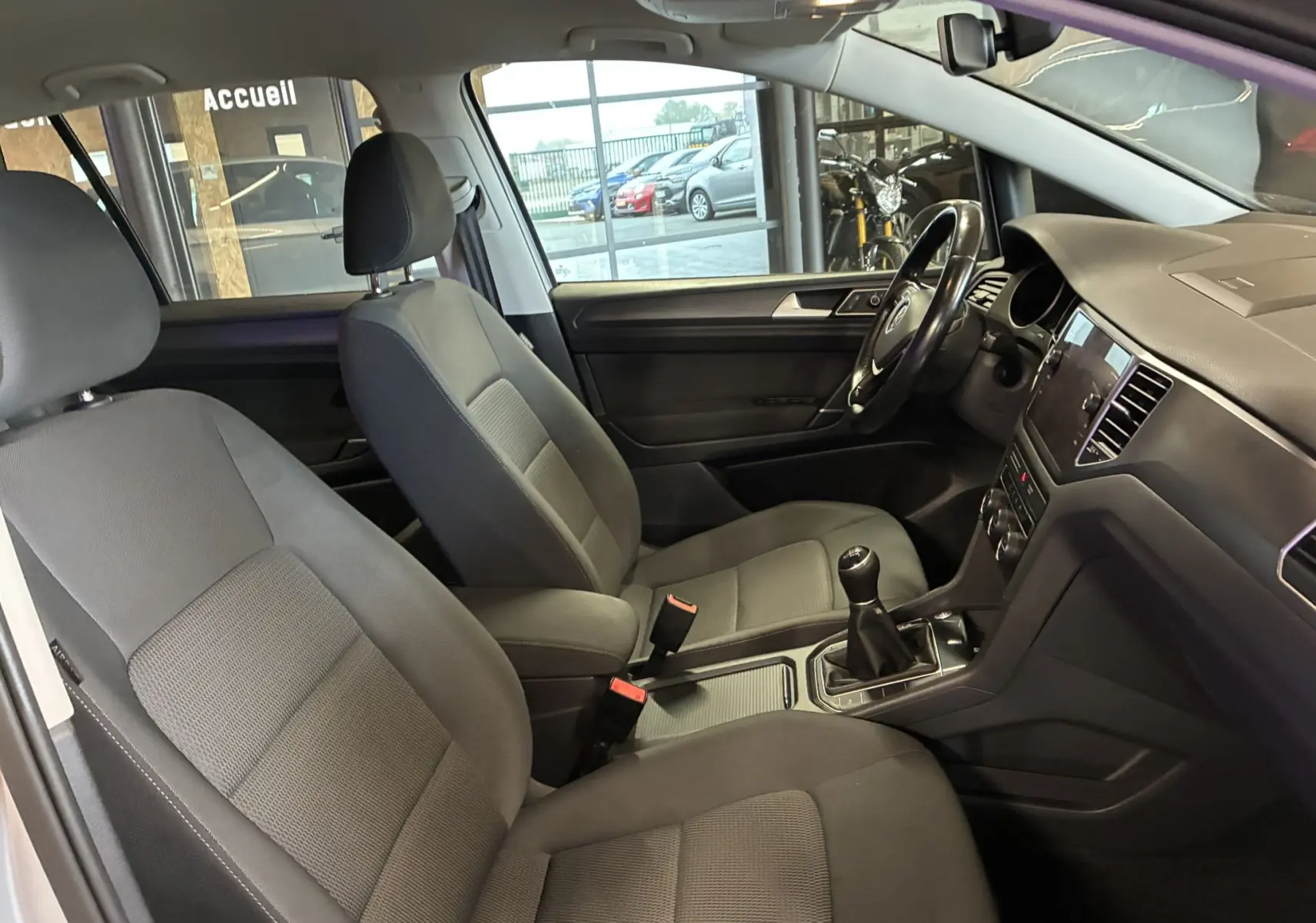 Intérieur gris noir de la Volkswagen Golf Sportsvan 2019, vue côté droit sur les sièges avant et le tableau de bord avec boîte manuelle.