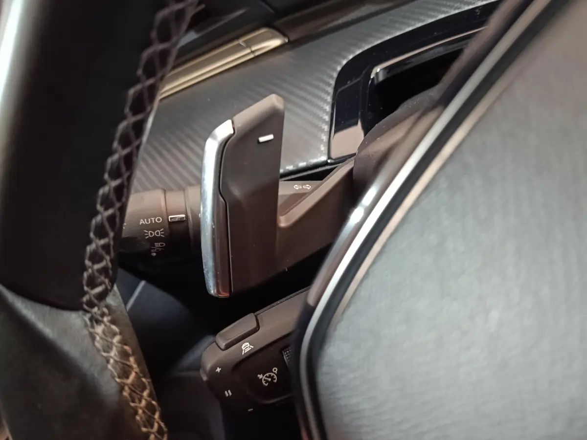 Gros plan sur les palettes au volant et commandes de clignotants du Peugeot 508 gris clair 2020, intérieur noir.