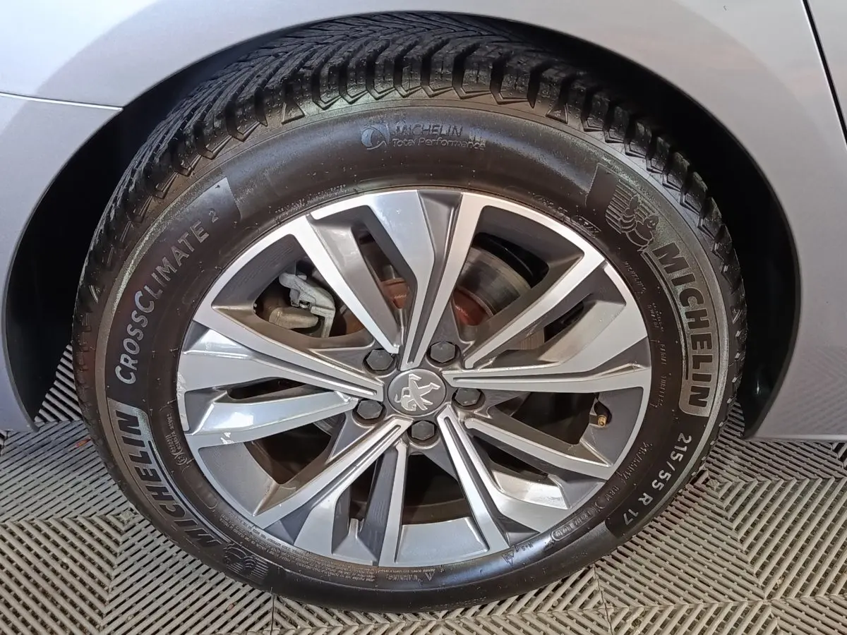 Gros plan sur la roue avant droite gris clair de la Peugeot 508 avec jante alliage et pneu Michelin CrossClimate 2.