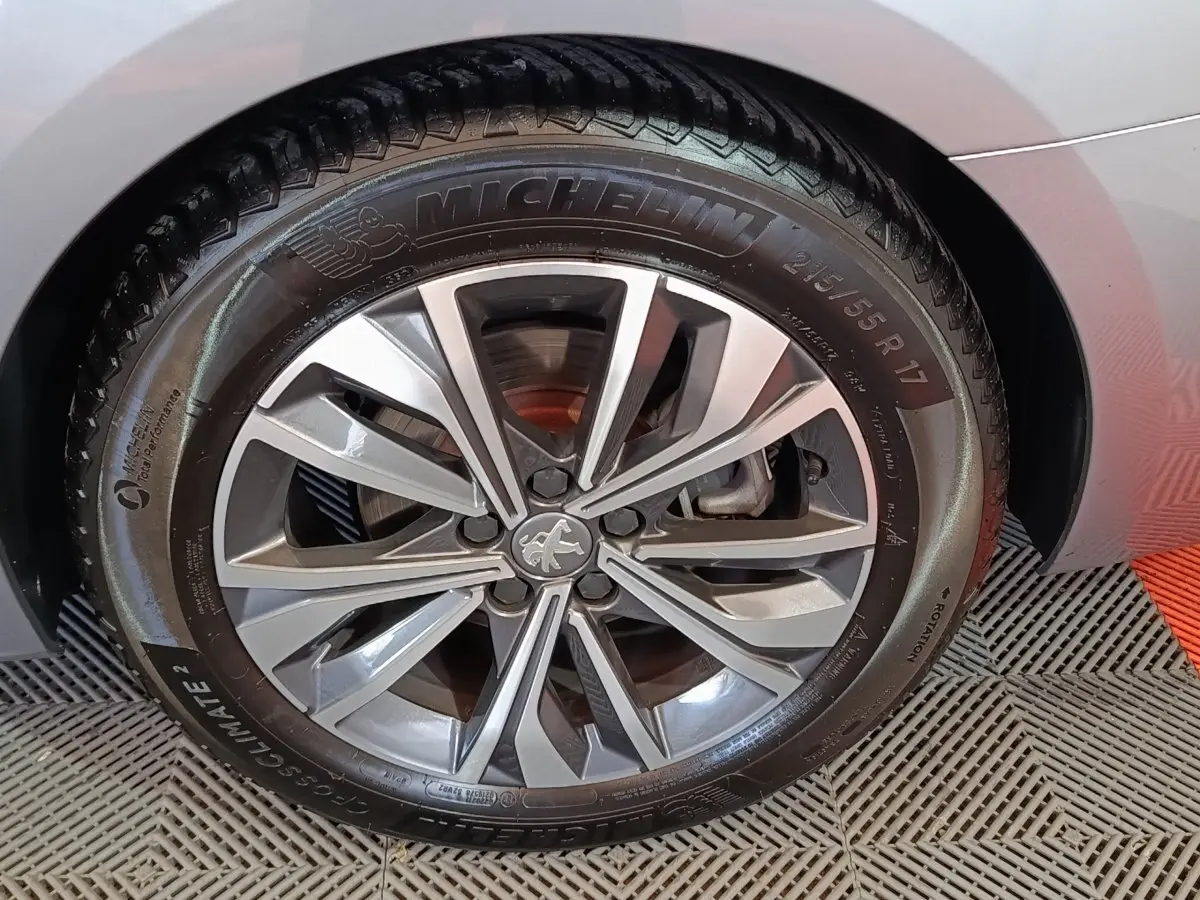 Gros plan sur la roue avant droite gris clair d'une Peugeot 508 BlueHDi 130 avec jante alliage et pneu Michelin.