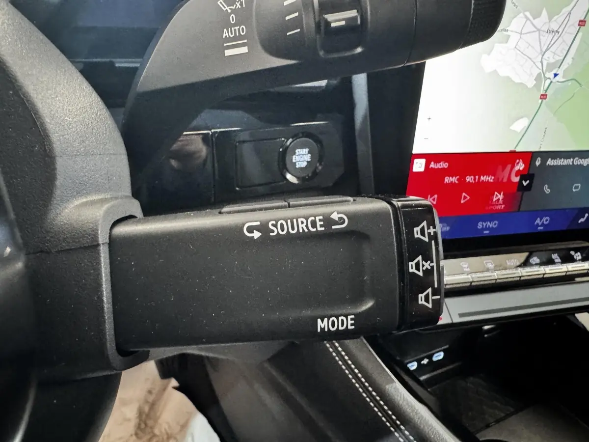 Détail intérieur du levier multifonction noir avec commandes audio et écran tactile de navigation du Renault Espace 2025.