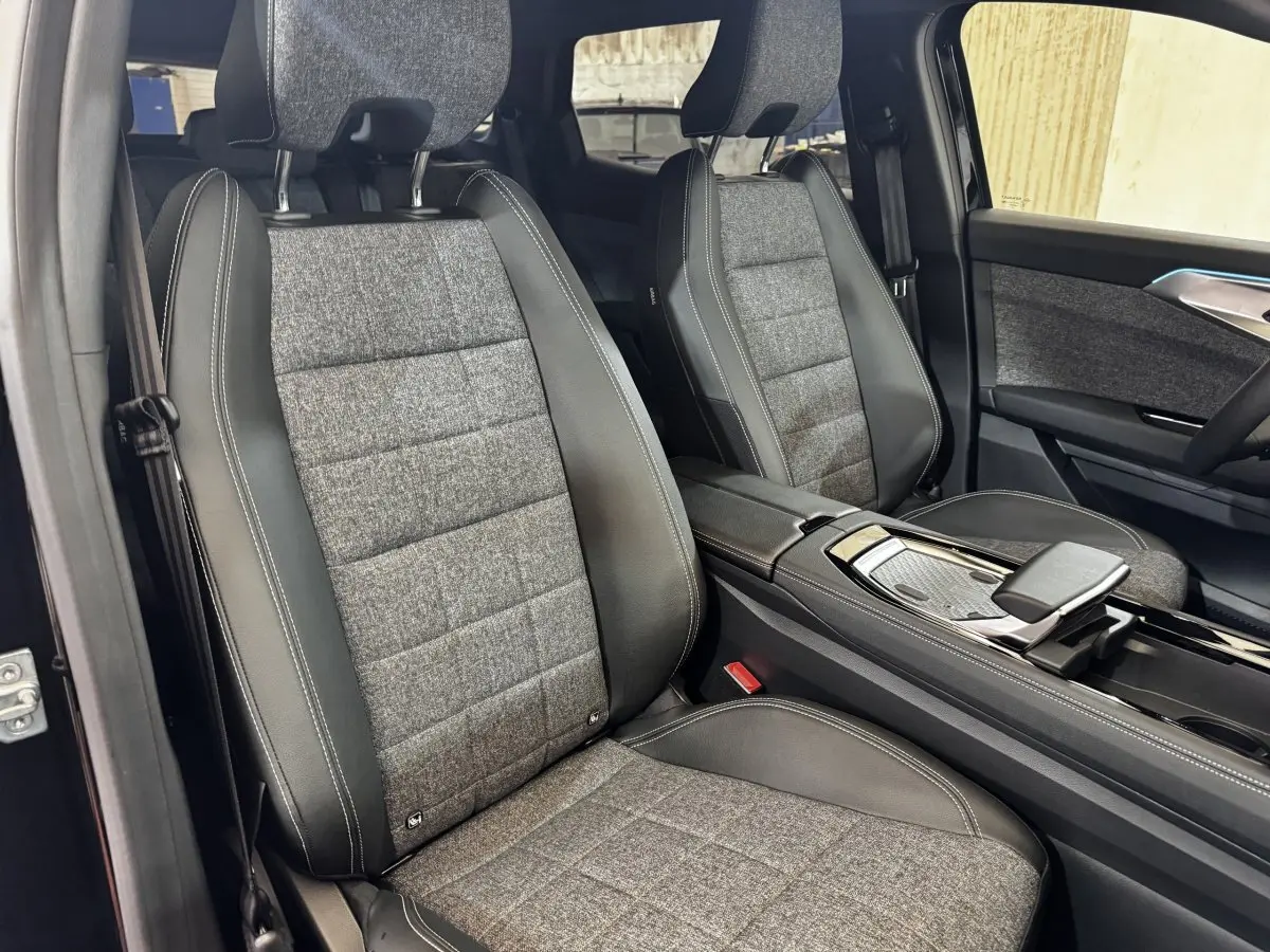 Vue intérieure côté gauche des sièges avant en tissu gris et cuir noir du Renault Espace 2025 techno 7PL E-Tech hybride.