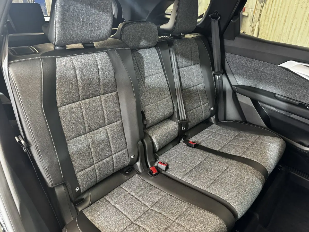 Vue intérieure côté droit sur la banquette arrière grise et noire du Renault Espace 2025 avec ceintures et appuie-têtes visibles.