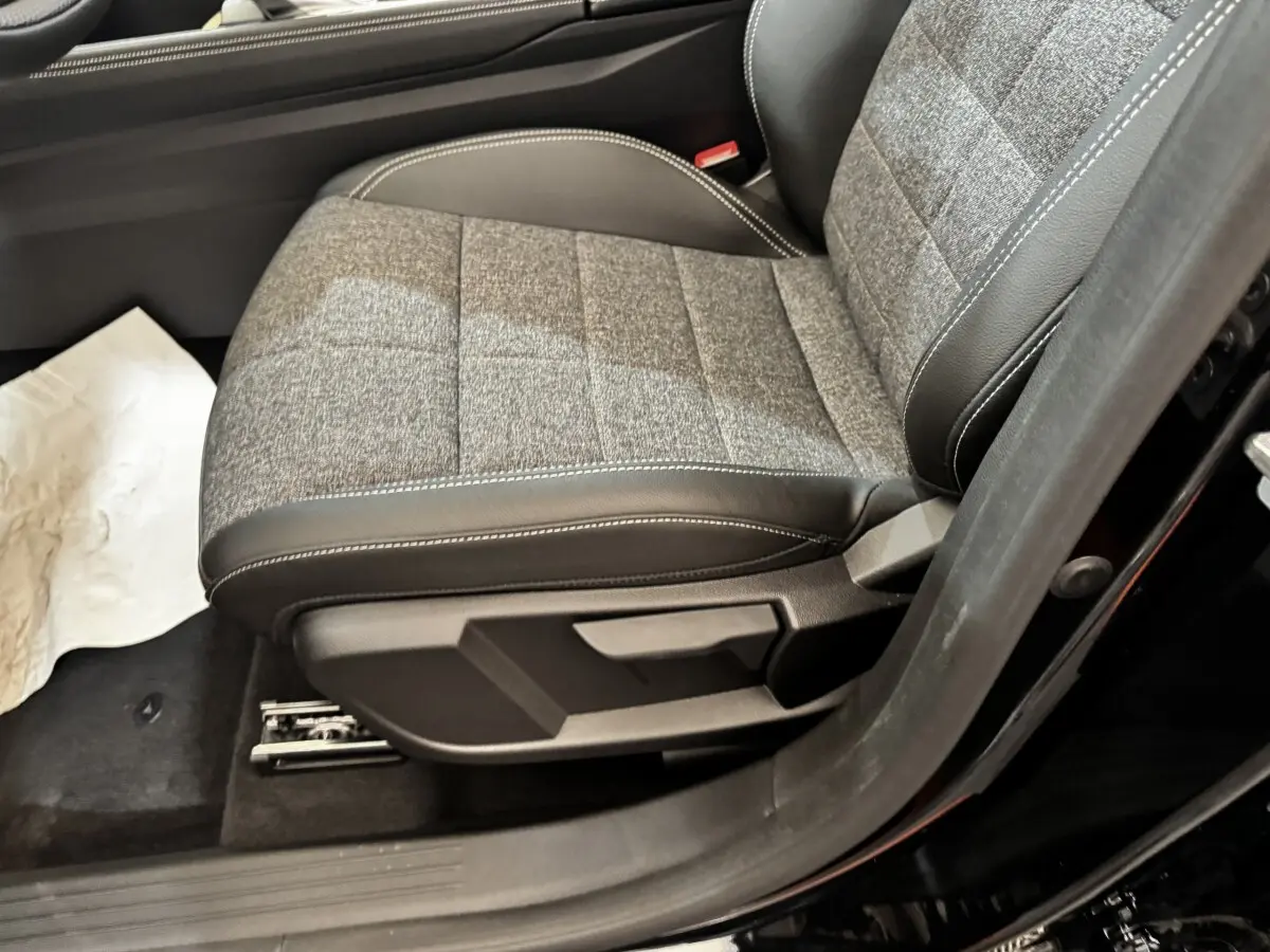 Gros plan sur le siège avant droit gris et noir du Renault Espace Techno 7PL E-Tech hybride noir 2025.