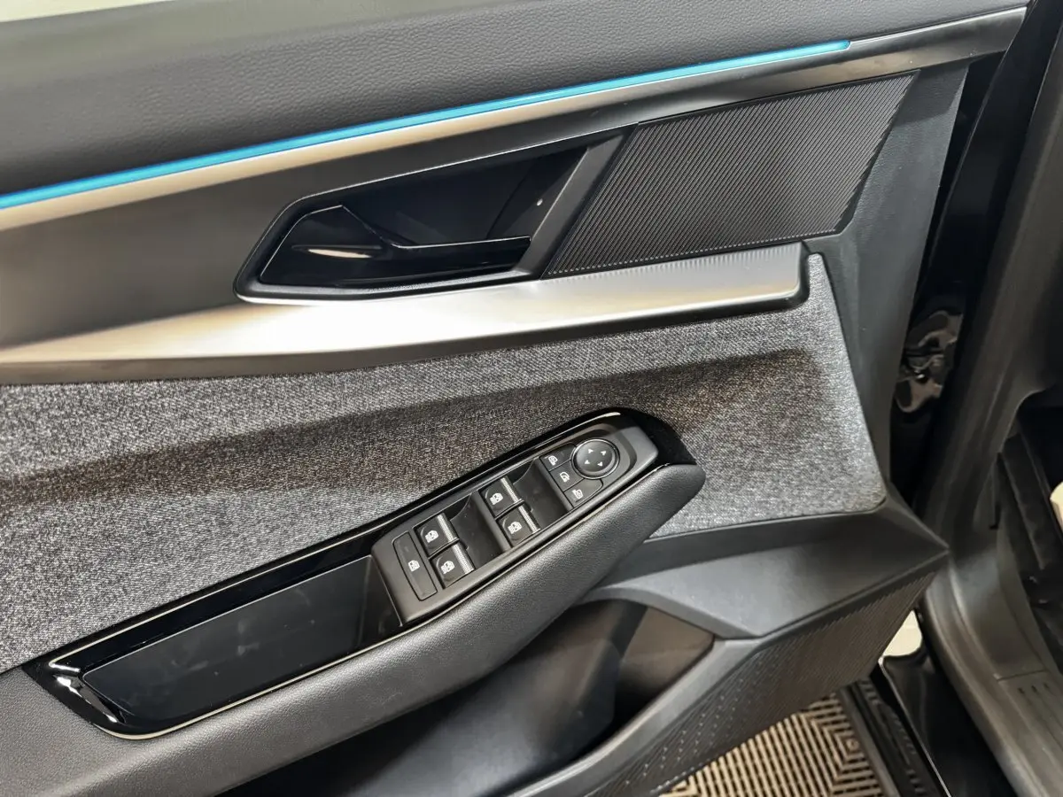 Détail de la porte côté conducteur du Renault Espace 2025, avec commandes de vitres et garniture tissu grise.