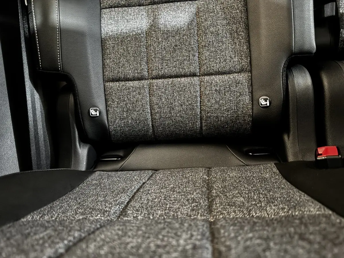 Gros plan sur la banquette arrière grise et noire du Renault Espace 2025, montrant les fixations Isofix et la ceinture rouge.