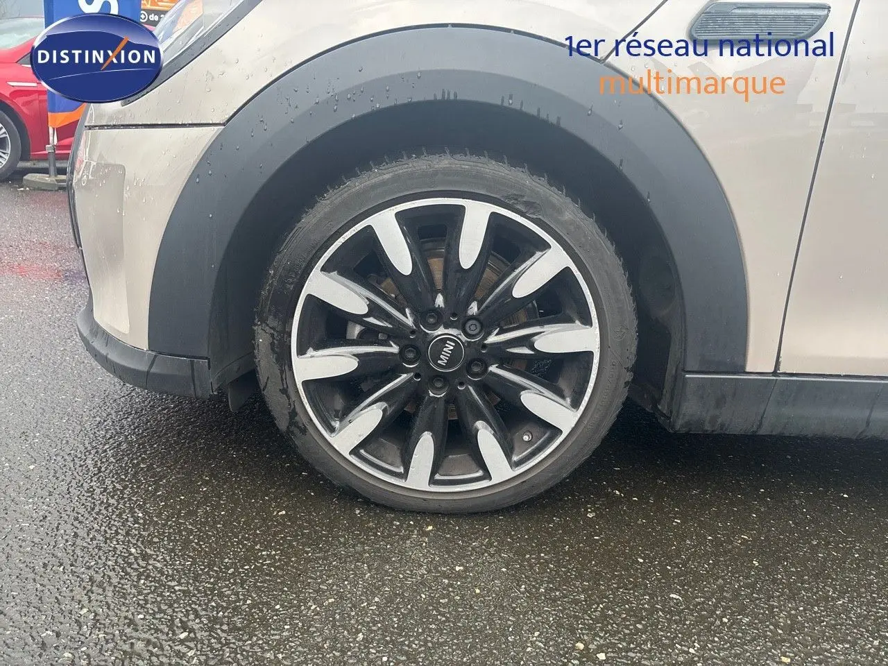 Gros plan sur la roue avant gauche d'une MINI 2023 couleur rooftop grey metal avec jante bi-ton noire et argent.