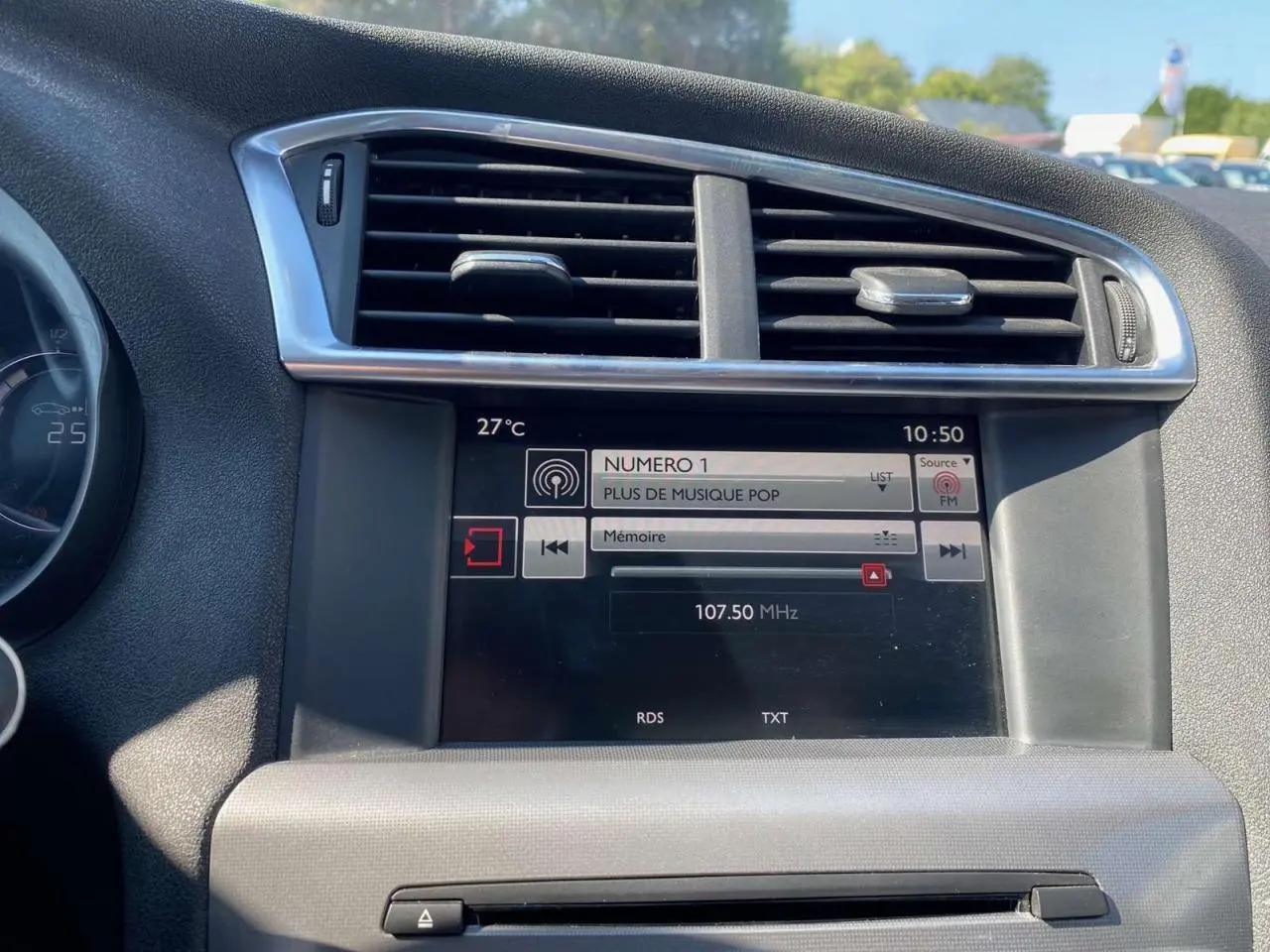 Tableau de bord de Citroën C4 2015 avec écran tactile radio et ventilation centrale en vue frontale rapprochée.