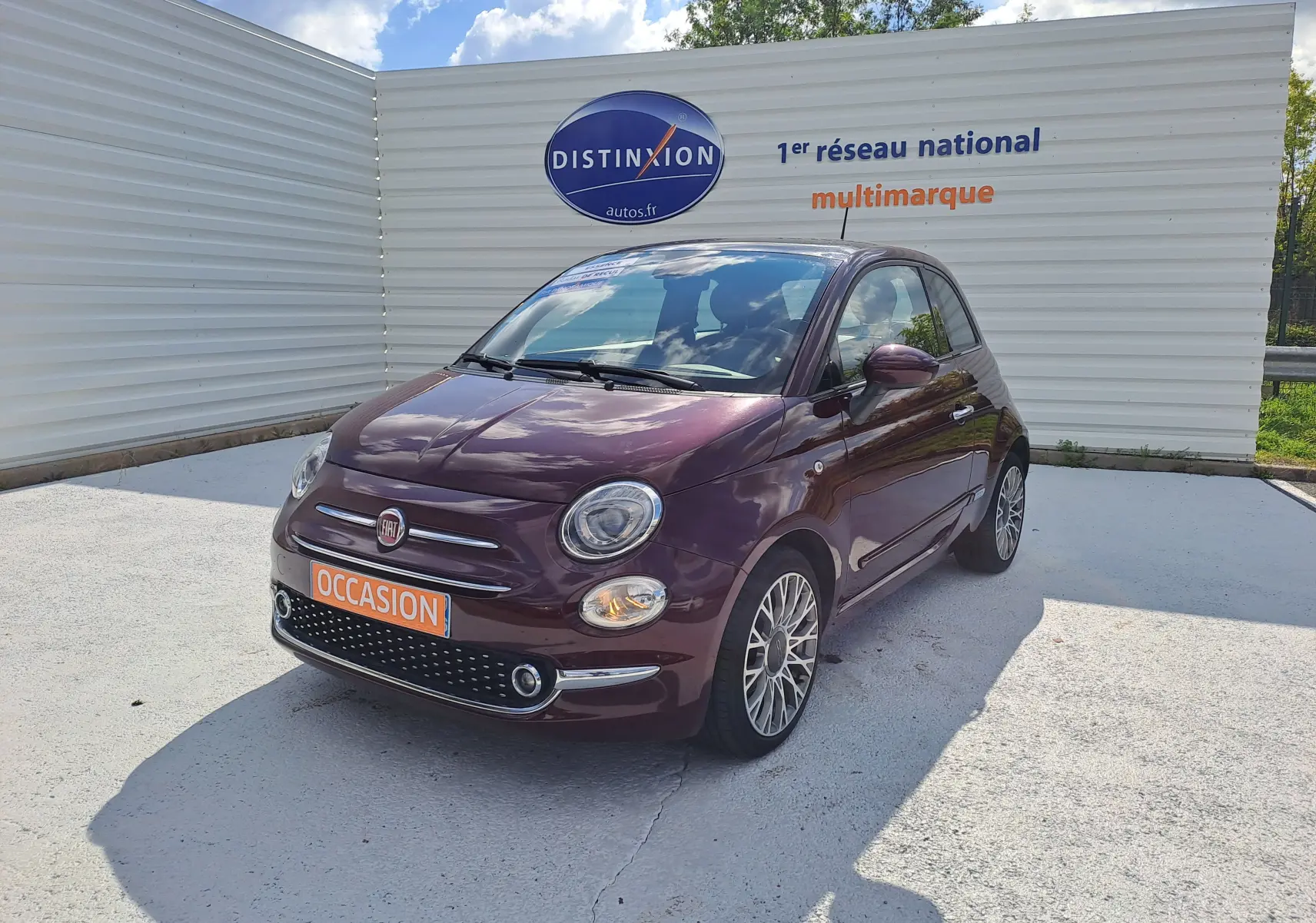 Fiat 500 Opera Bordeaux métal vue 3/4 avant droit, avec calandre chromée et jantes alliage multibranches.