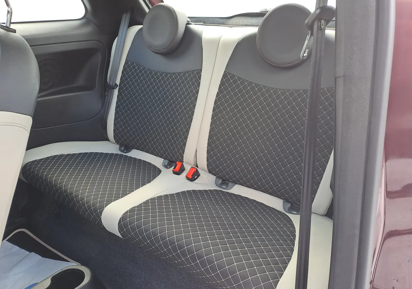 Vue intérieure du siège arrière de la Fiat 500 Opera Bordeaux Métal 2020 avec sellerie noire et beige à motif losanges.