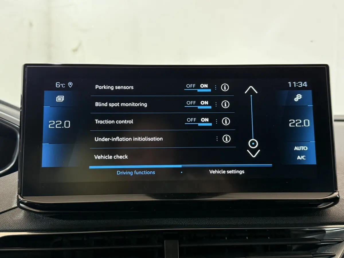 Écran tactile central du Peugeot 5008 gris clair affichant les réglages d'aide à la conduite et climatisation.
