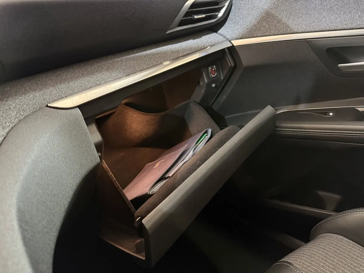 Vue intérieure côté passager du Peugeot 5008 gris clair 2021, boîte auto, avec boîte à gants ouverte et livret à l'intérieur.
