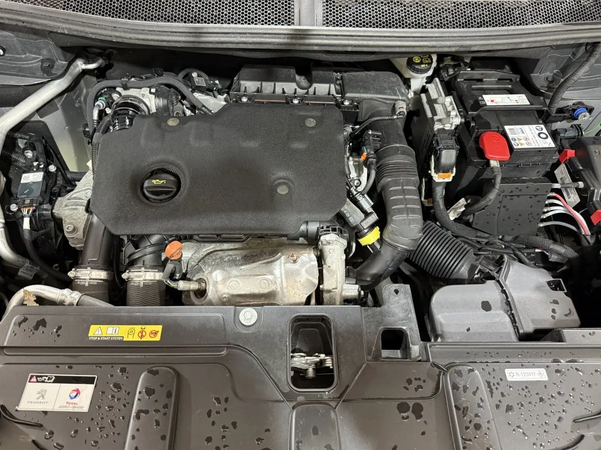 Vue rapprochée du moteur diesel gris sous le capot ouvert du Peugeot 5008 BlueHDi 130 S&S EAT8 Allure Pack 2021.