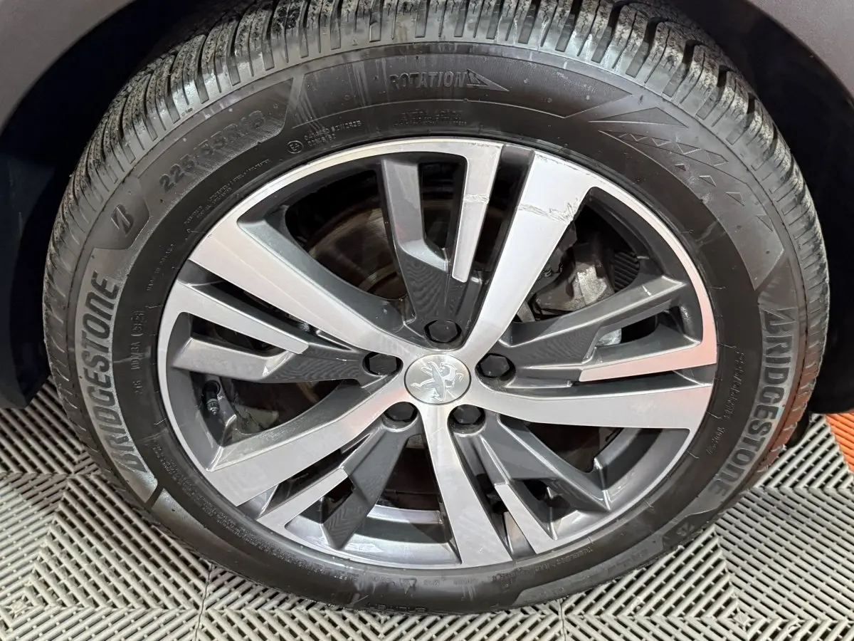 Gros plan sur la jante alliage gris foncé du Peugeot 5008 gris clair, avec pneu Bridgestone visible.