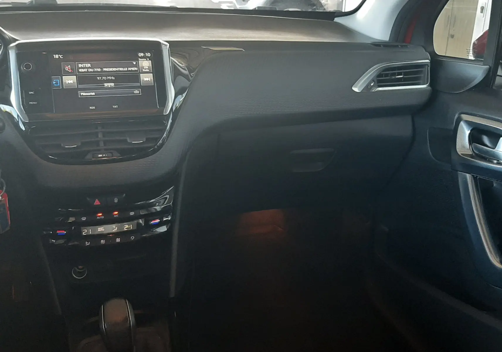 Vue intérieure côté passager du tableau de bord noir du Peugeot 2008 2016 avec écran tactile et commandes climatisation.