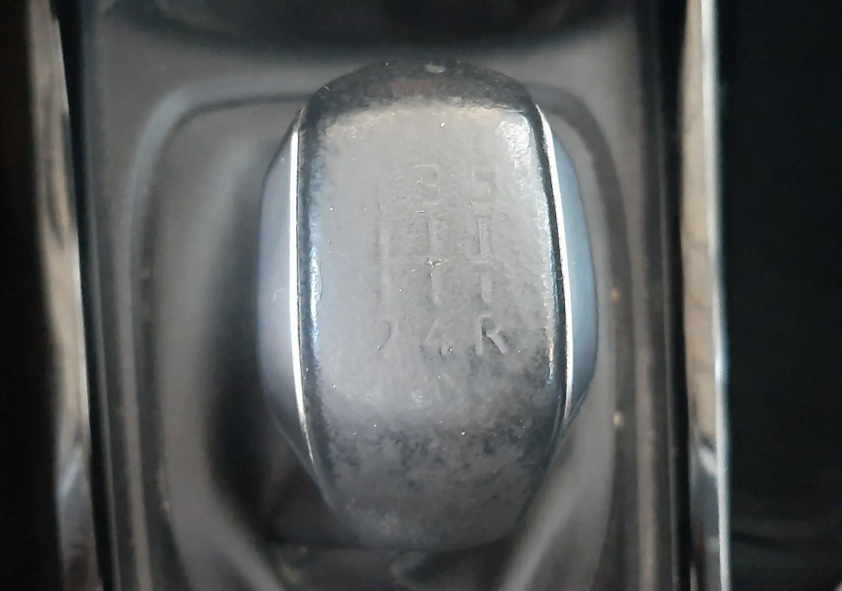 Gros plan sur le levier de vitesses manuel noir de la Peugeot 2008 rouge, montrant les positions des rapports.