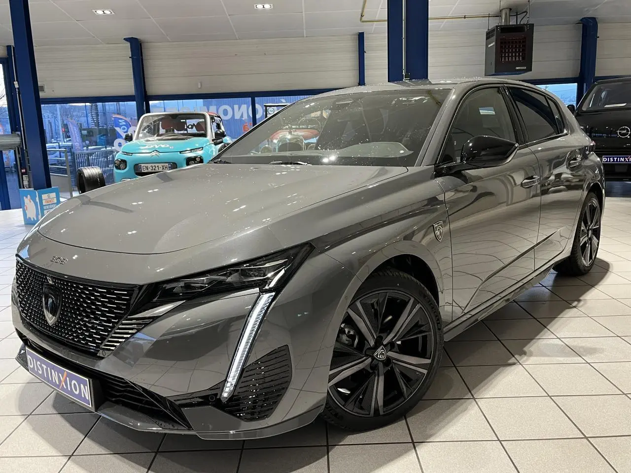 Peugeot 308 Gris Selenium vue 3/4 avant droit, calandre noire vernie et jantes alliage 18'' Kamakura diamantées.