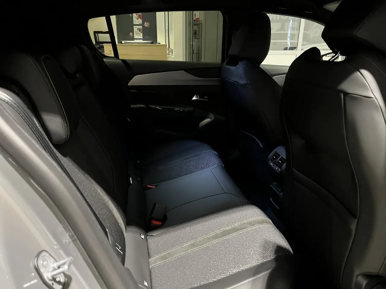 Vue intérieure côté gauche de la banquette arrière en sellerie tri matières noire du Peugeot 308 Gris Selenium 2024.