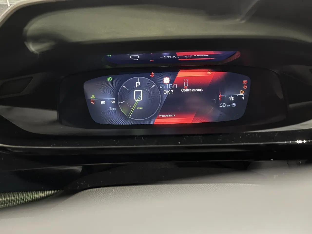Combiné numérique 10 pouces de la Peugeot 308 GT 2024 affichant vitesse, jauge et alerte coffre ouvert.