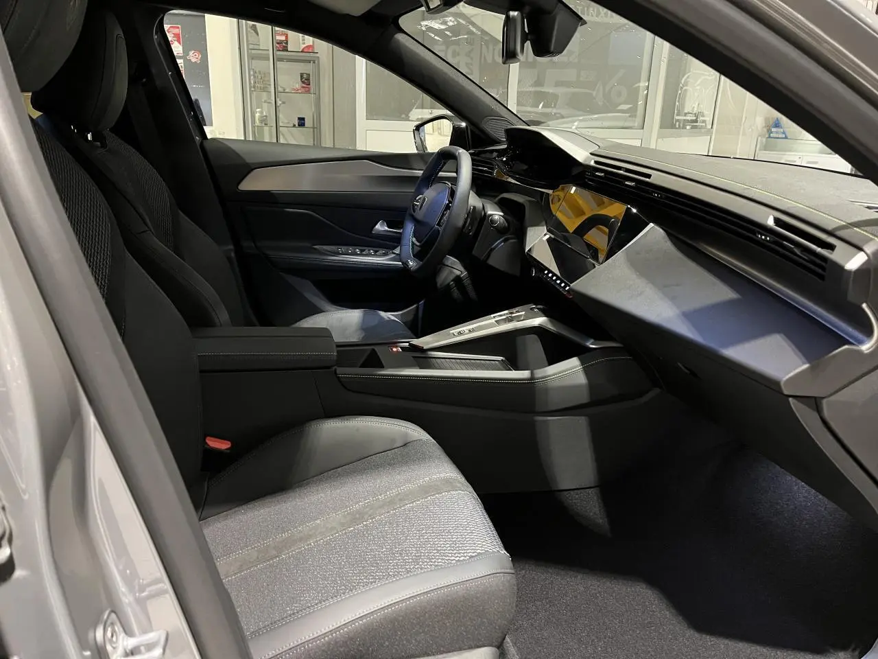 Intérieur avant droit de la Peugeot 308 2024 gris selenium, avec tableau de bord moderne et sellerie tri matières noire.