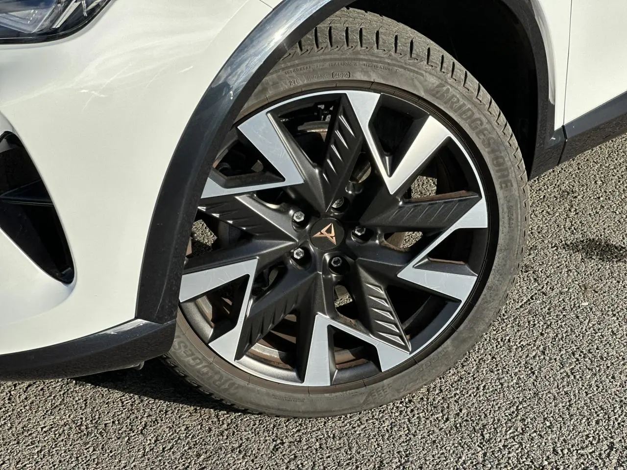 Gros plan sur la jante alliage 19'' Sandstorm noire et argent du côté avant droit du CUPRA Formentor Blanc Neige.