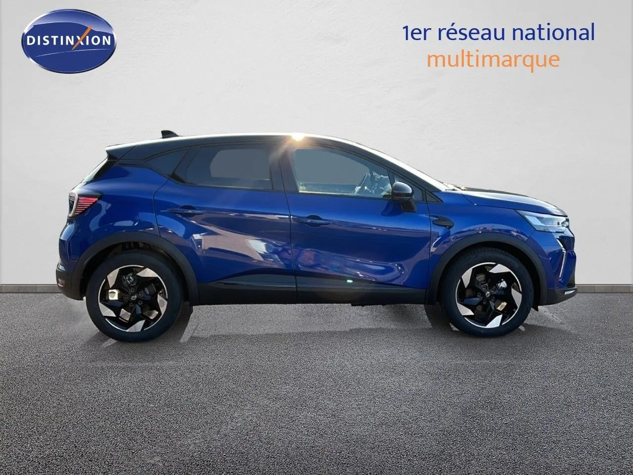 Profil côté gauche du Renault Captur E-TECH hybride 2025 en bleu Iron Metal avec toit noir et jantes noires distinctives.