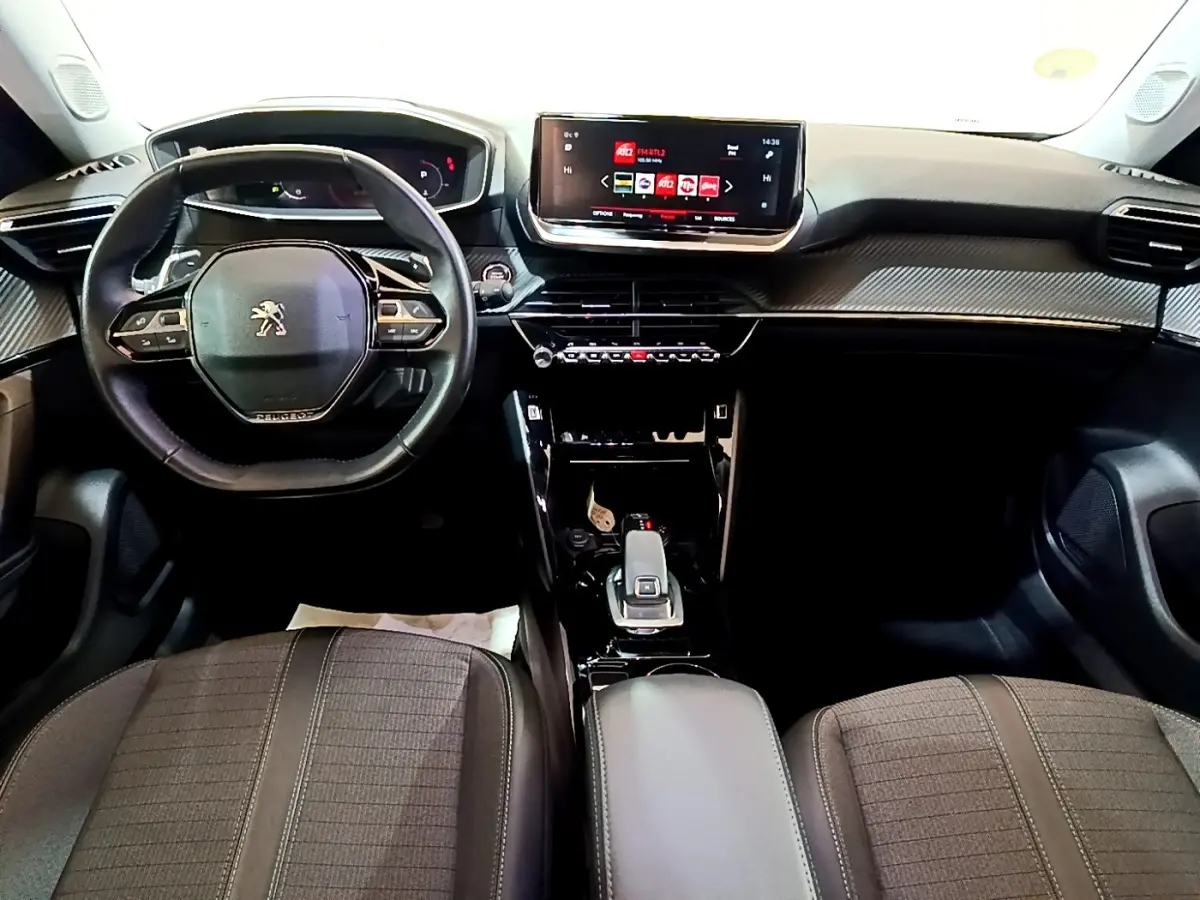 Vue intérieure avant du Peugeot 2008 2021, tableau de bord moderne avec écran tactile et volant cuir multifonctions.