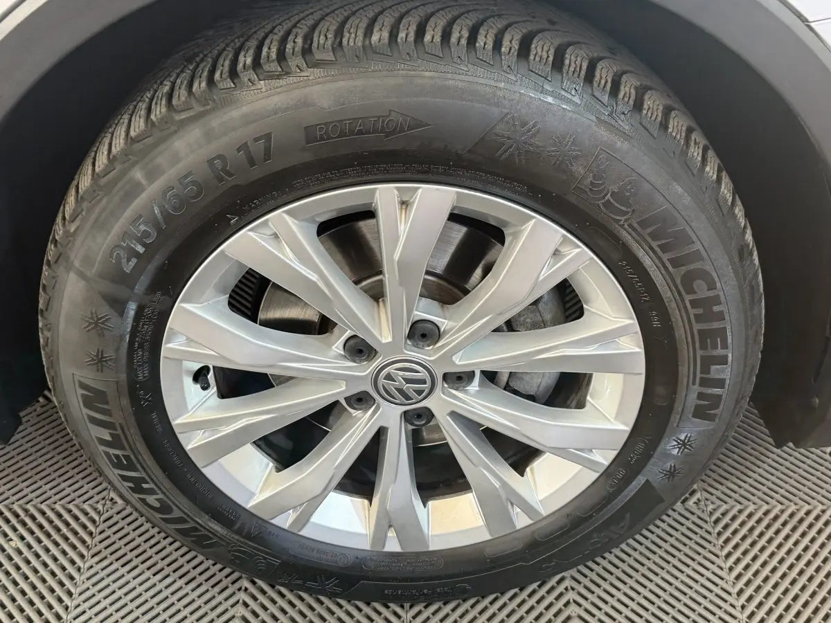 Gros plan sur la roue avant droite du Volkswagen Tiguan gris clair, avec jante alliage et pneu Michelin visible.