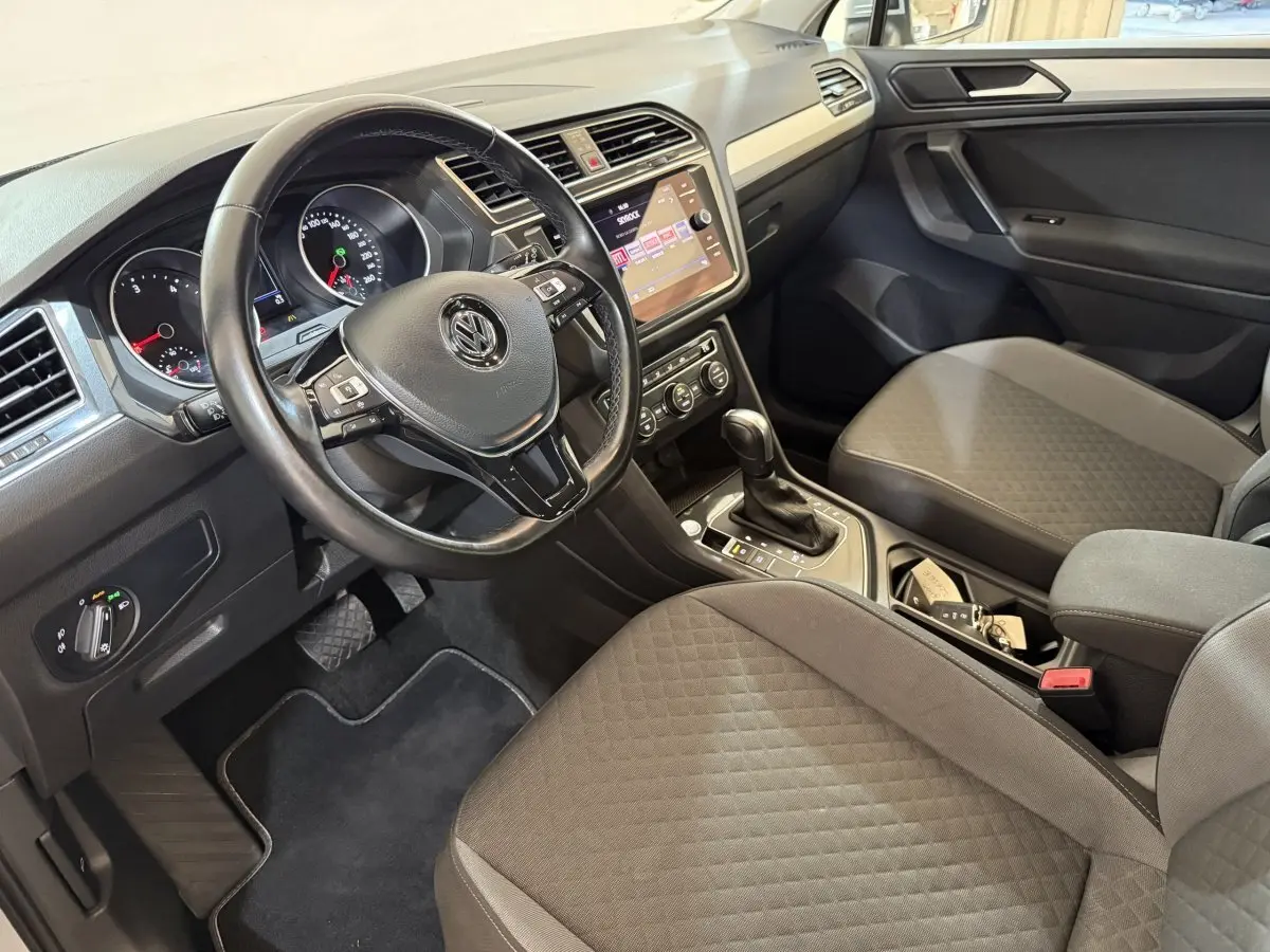 Vue intérieure côté conducteur du Volkswagen Tiguan 2020, volant cuir multifonctions et console centrale avec écran tactile.