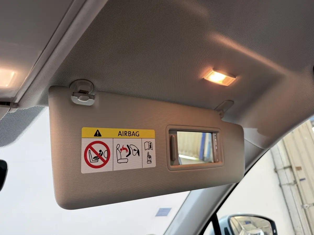 Désolé, l'image montre uniquement un pare-soleil intérieur avec miroir et avertissement airbag, sans vue extérieure du Volkswagen Tiguan.