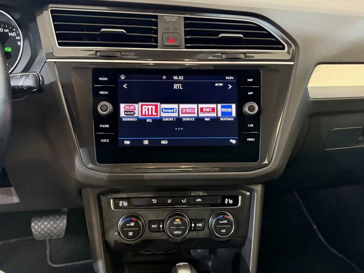 Vue rapprochée du tableau de bord du Volkswagen Tiguan 2020 gris clair, avec écran tactile central et commandes climatisation.
