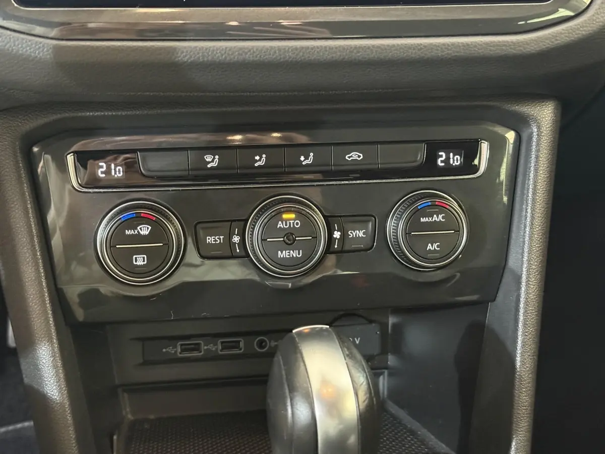 Gros plan sur la console centrale du Volkswagen Tiguan 2020, montrant les commandes de climatisation et le levier de vitesse.