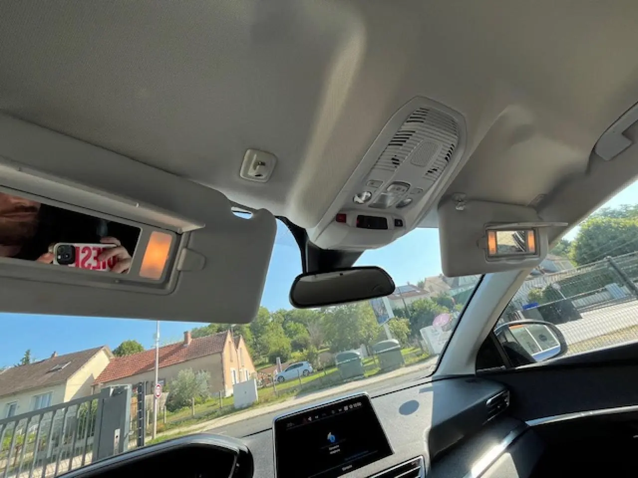 Vue intérieure du Peugeot 3008 2016 montrant les pare-soleil avec miroirs éclairés et le toit clair en plein jour.