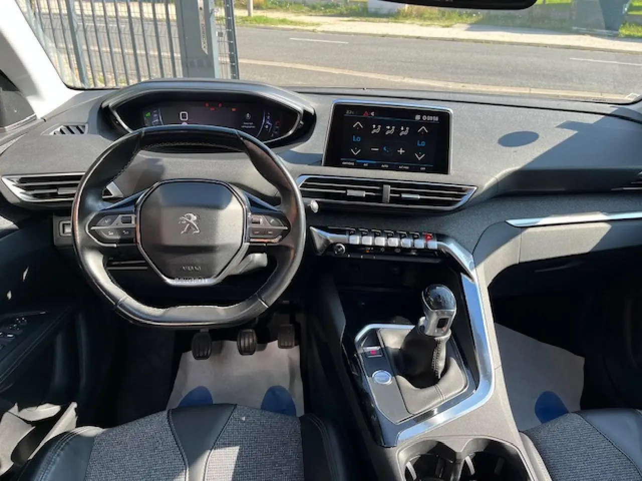 Intérieur du Peugeot 3008 2016 vu de face, volant compact, écran tactile et levier de vitesse manuel visibles.