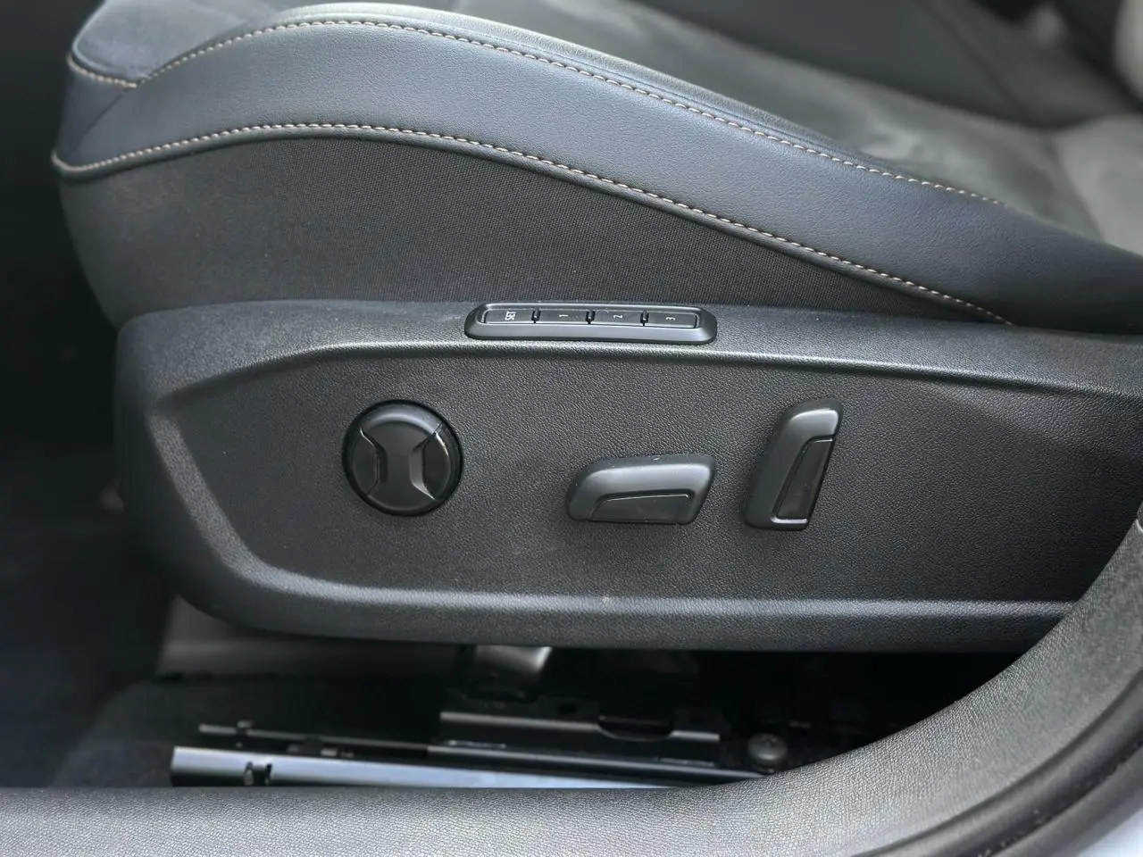 Gros plan sur les commandes électriques du siège conducteur en suédine noir asphalte du CUPRA Formentor Blanc Neige 2025.