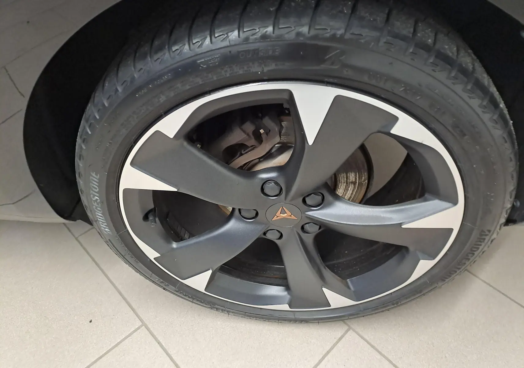 Gros plan sur la jante noire et argentée avec logo CUPRA d'une CUPRA Leon 1.5 TSI 150 DS7 V Noir Minuit 2023.