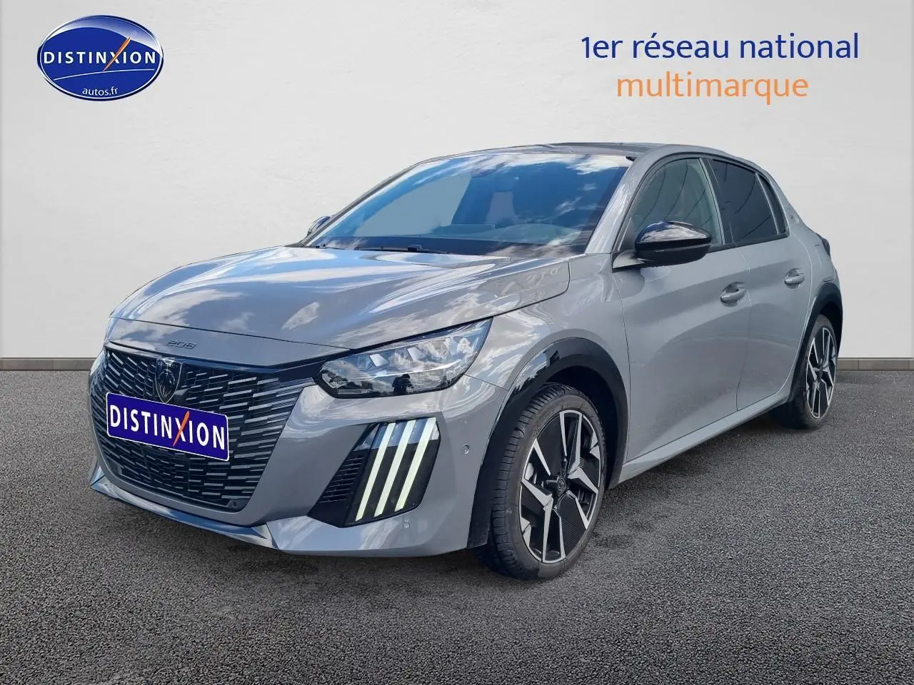 PEUGEOT 208 gris en 3/4 avant droit, avec calandre noire et feux LED verticaux distinctifs.