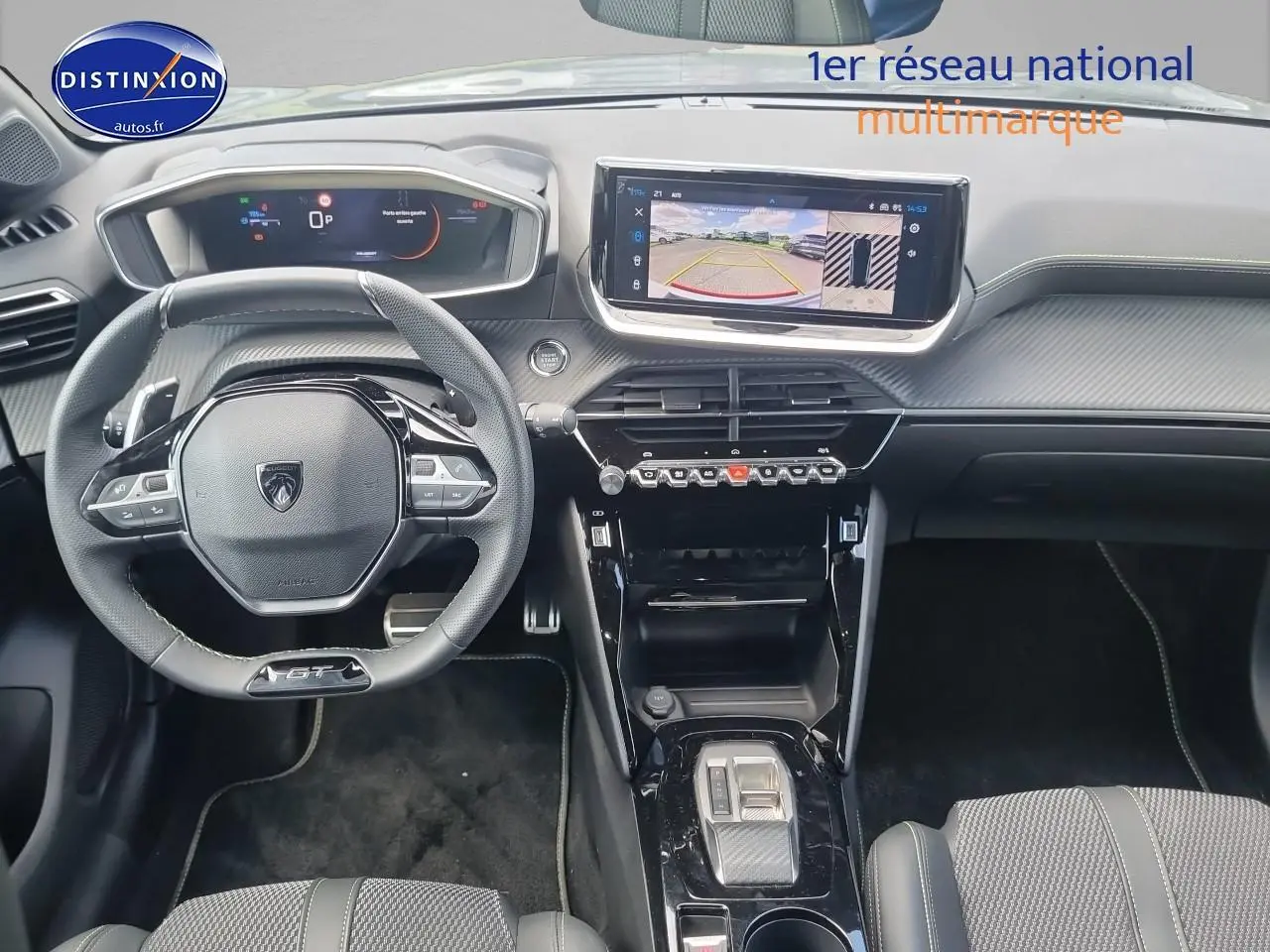 Vue intérieure frontale du tableau de bord et volant cuir noir de la Peugeot 208 gris, avec écran tactile affichant la caméra 360°.