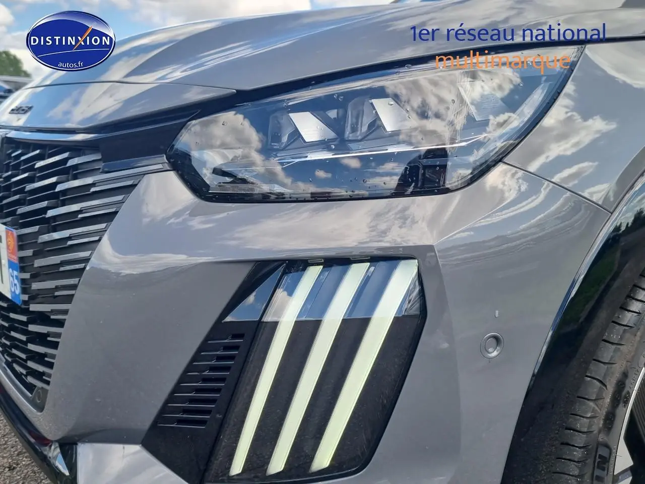 Gros plan sur l'avant droit gris d'une Peugeot 208 1.2 hybrid 136 GT avec phares et feux LED distinctifs.